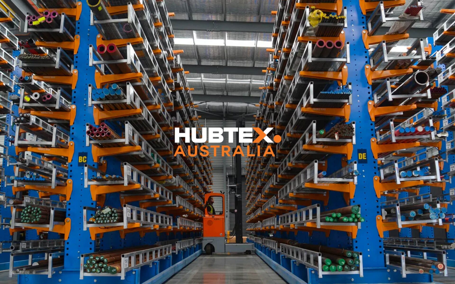 Interior view of a Hubtex warehouse showcasing organized storage with colorful pipes and equipment.