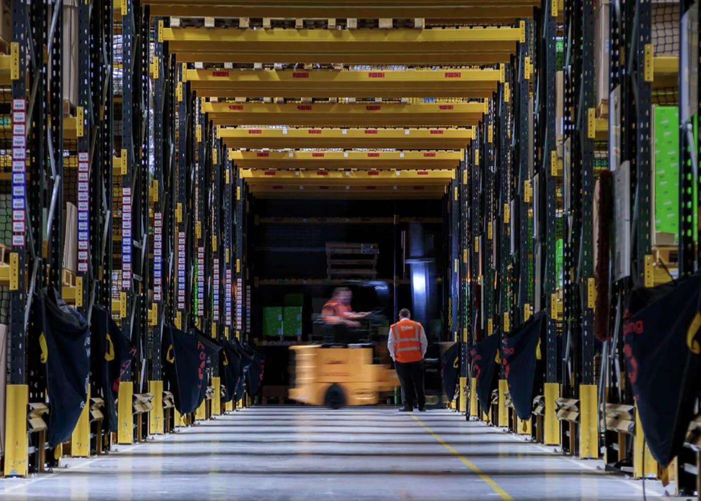 Efficient Warehouse Logistics with Forklift Interior view of a warehouse with shelves and a worker operating a forklift