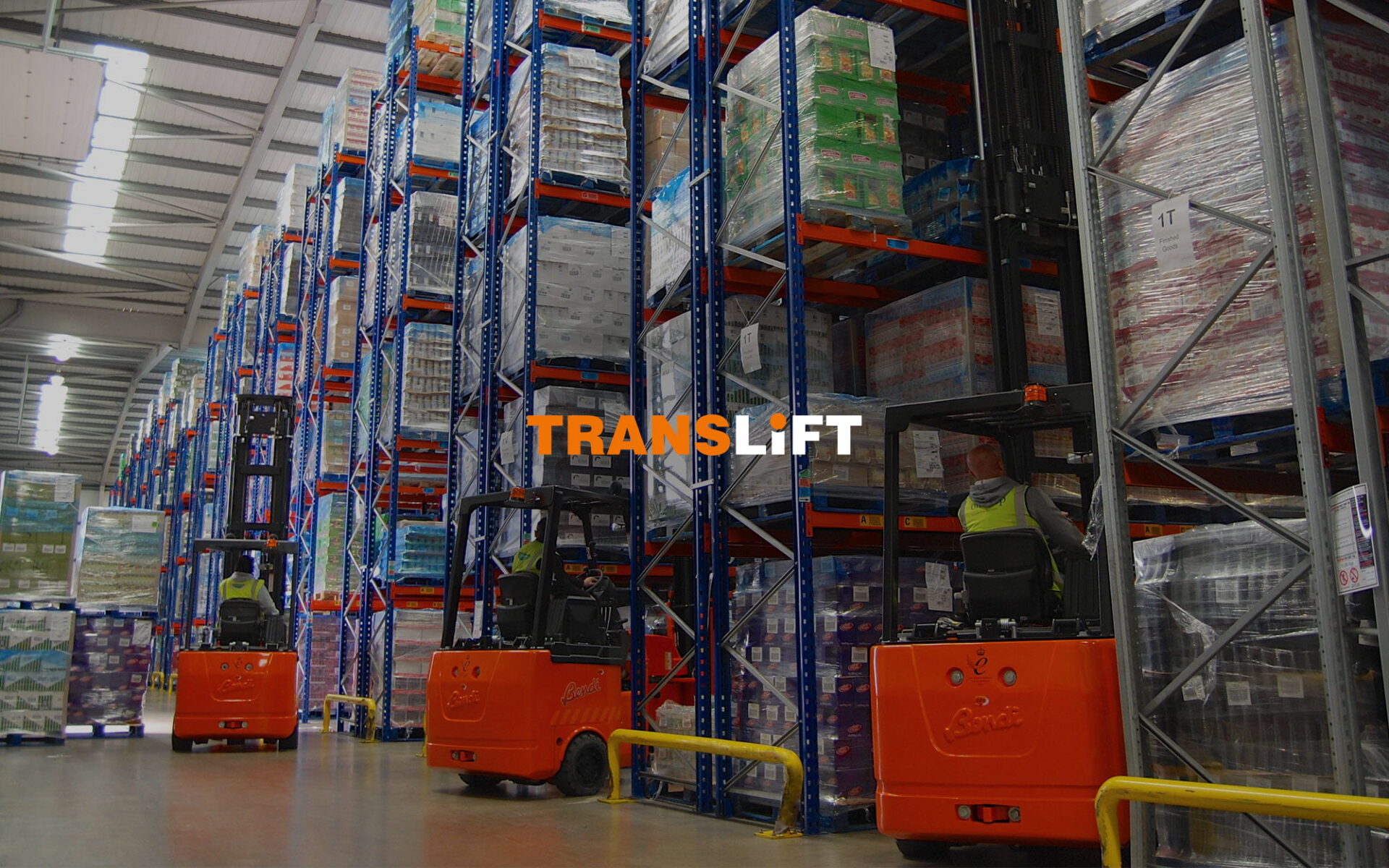 Interior view of a warehouse featuring forklifts and tall stacks of pallets on shelves