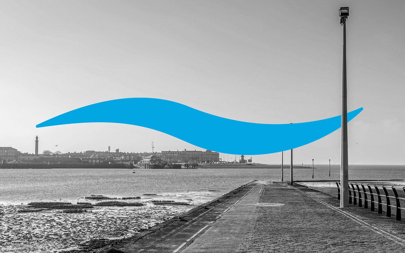 A beautiful black and white image of a waterfront path, featuring a vibrant blue wave graphic overlay.